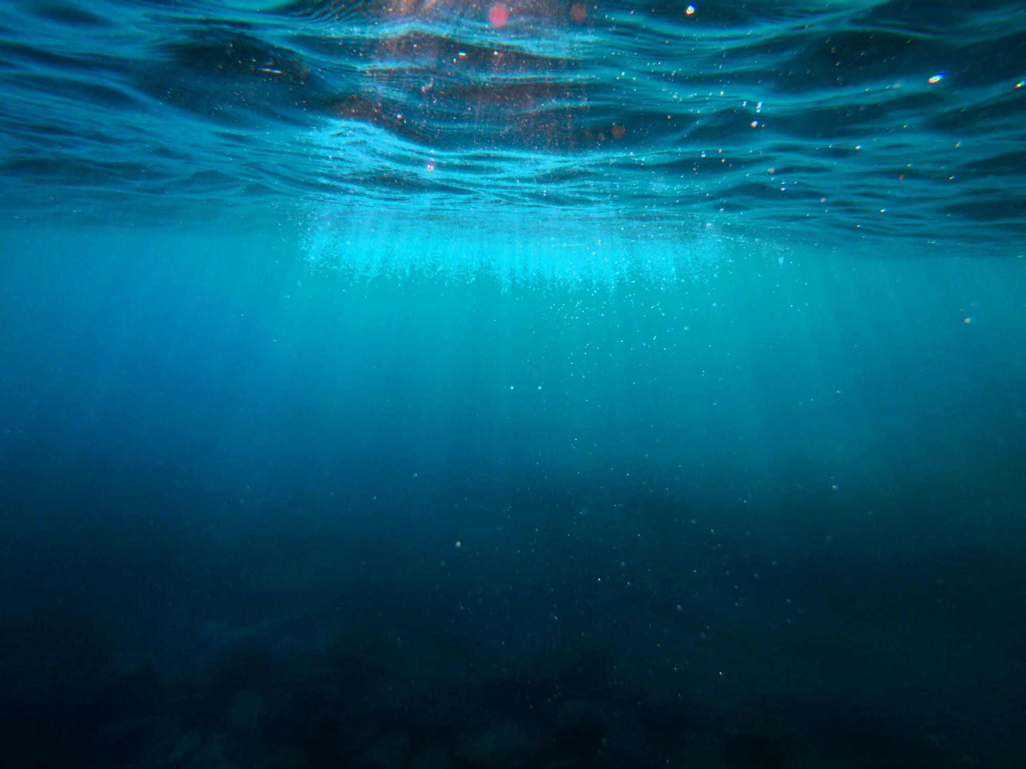 Shafts of light fading into deep, dark water
